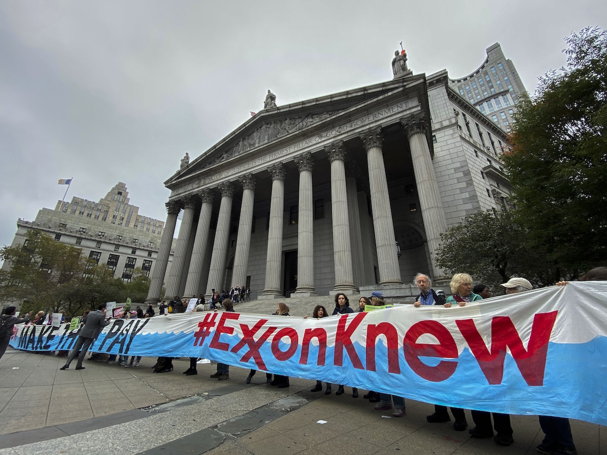 Protestors against ExxonMobil hold a sign saying 'Exxon Knew' outside the New York State Supreme Court building