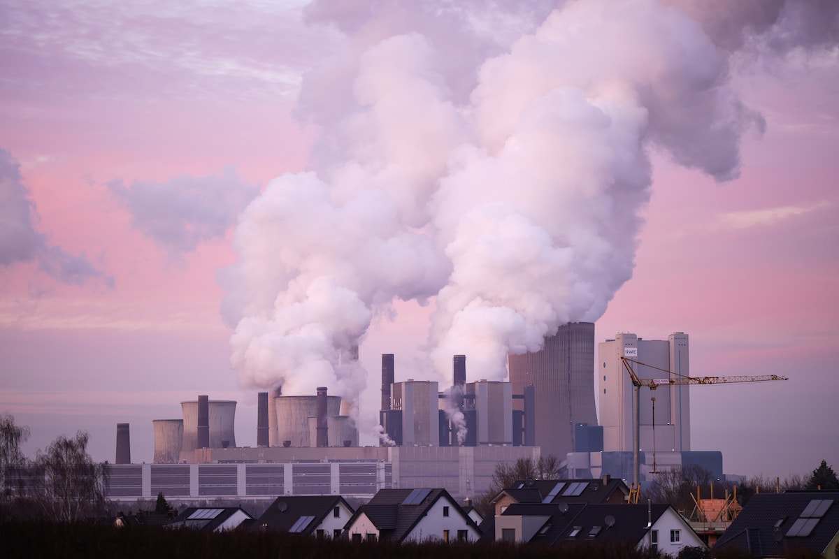 Steam rises from cooling towers of the Niederaussem coal-fired power plant near houses in Niederaussem, Germany