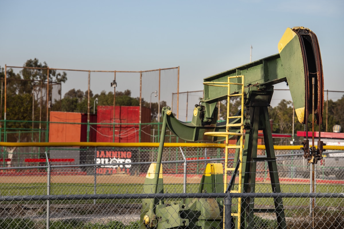 An oil derrick pump near a baseball diamond in the Wilmington neighborhood of Los Angeles, California