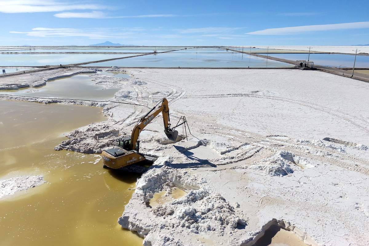A backhoe digs a salt recovery pool for raw material to produce lithium, in Bolivia