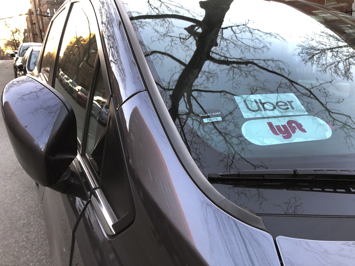 An Uber and Lyft sign in the windshield of a car in Queens, New York City