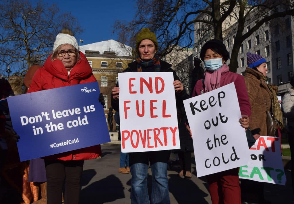 Protesters hold placards calling for an end to fuel poverty