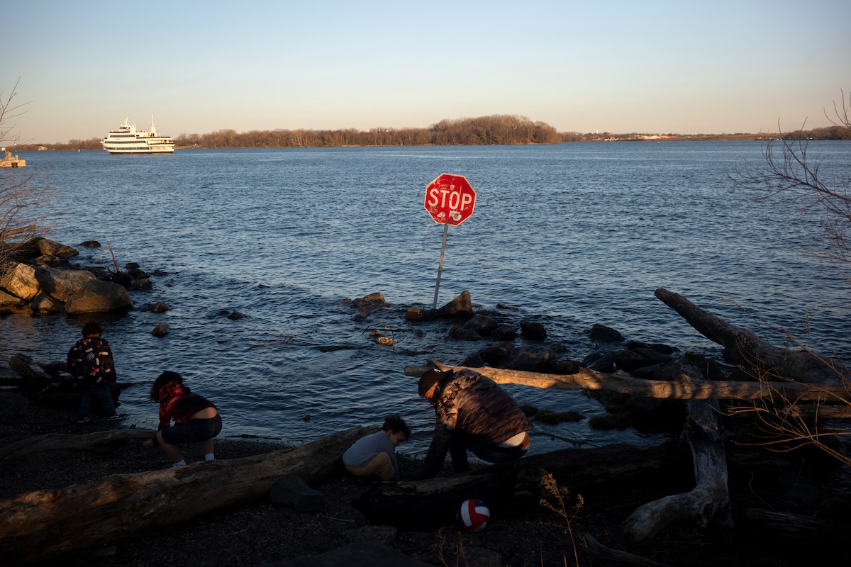Children play along the Delaware River where a stop sign has been placed in the water following a chemical spill