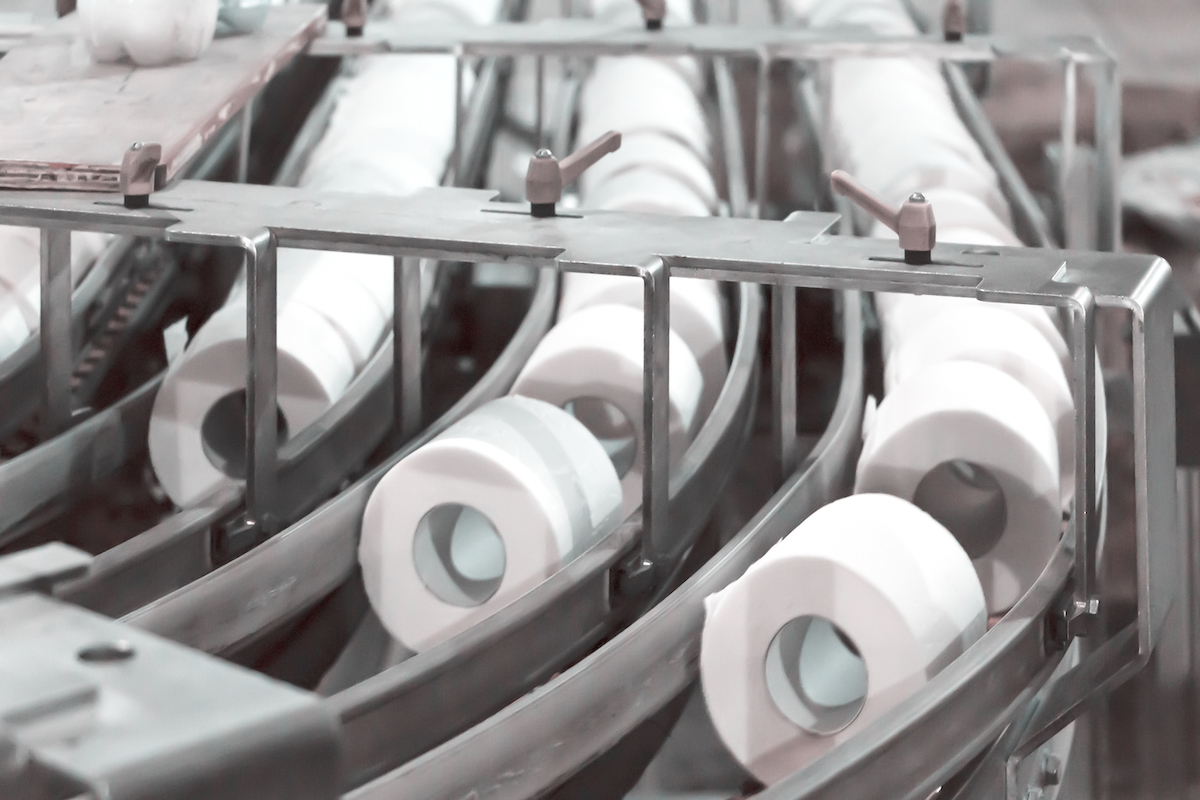 Rolls of toilet paper on a conveyor belt at a factory