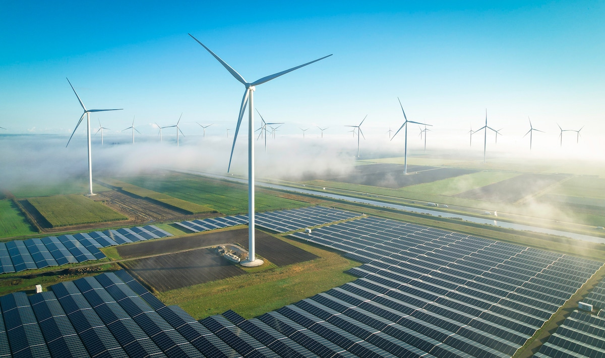 Aerial view of solar energy fields and wind turbines in foggy conditions in Muntendam, the Netherlands