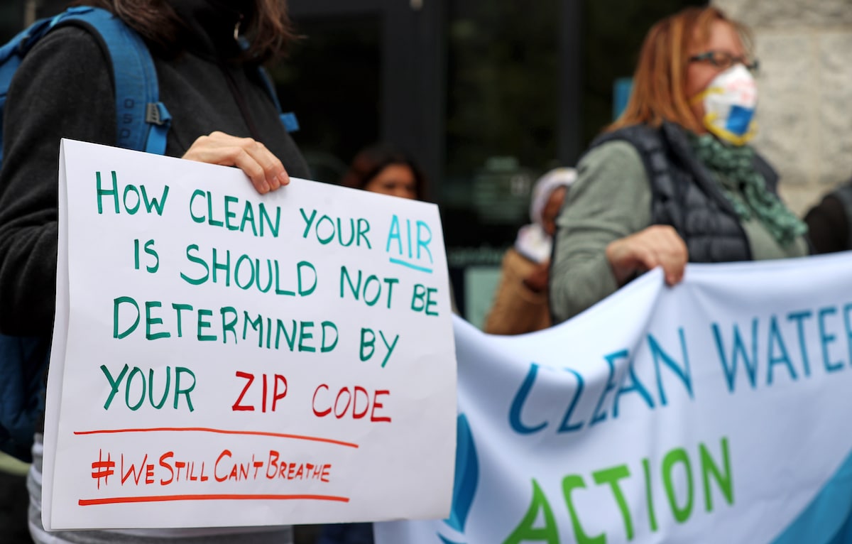 Environmental justice advocates hold signs calling on legislators to improve air quality in Boston, Massachusetts
