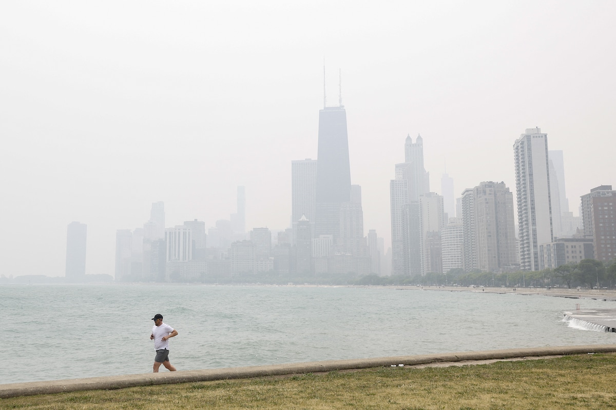 A jogger runs along the shoreline of Lake Michigan with heavy smoke from Canada’s wildfires in the background in Chicago, Illinois