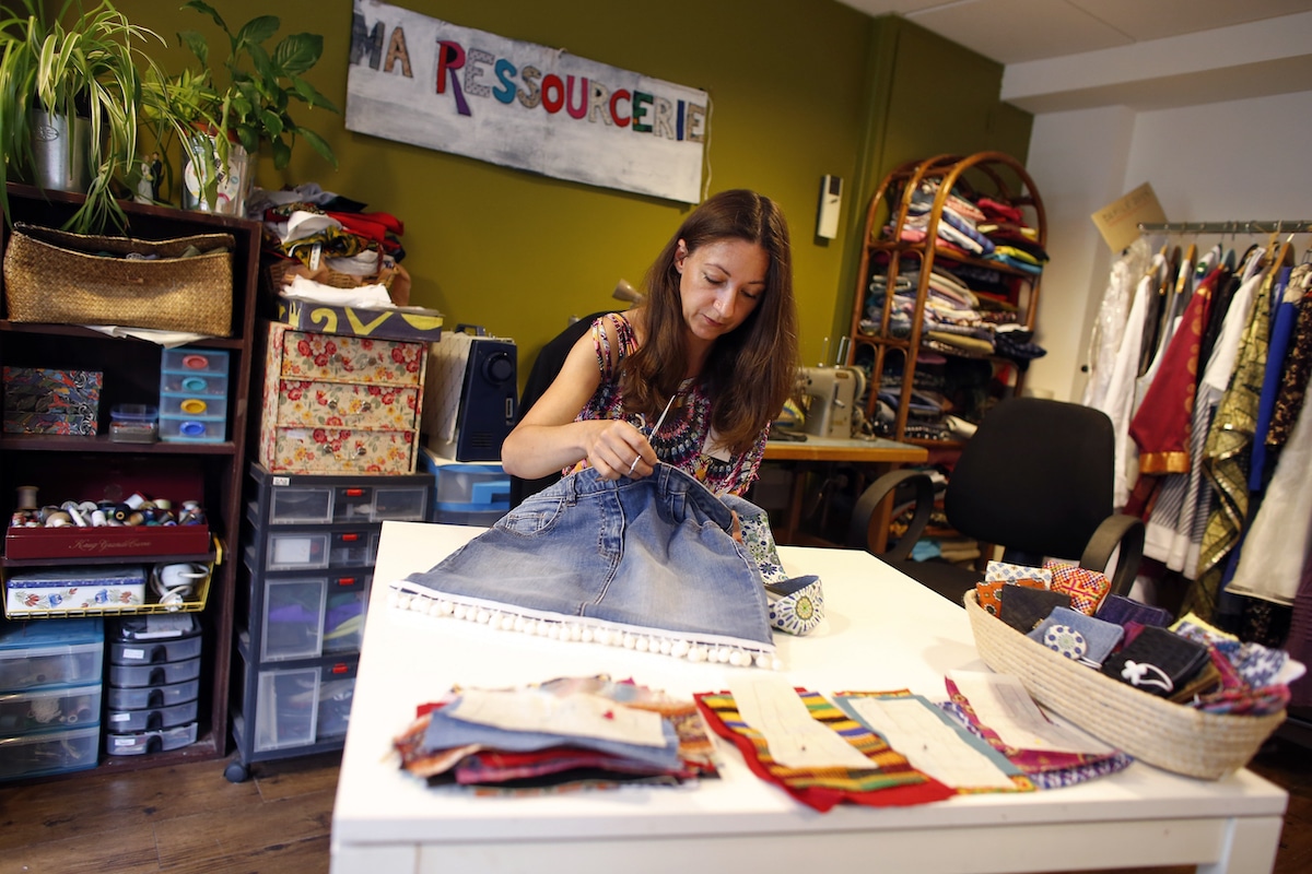 An employee sews a bag made from old jeans at Ma Ressourcerie, a reuse shop in Paris that collects and repairs clothing