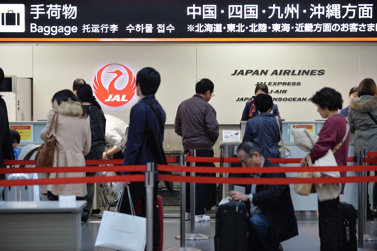 Passengers at a Japan Airlines (JAL) check-in counter at Tokyo's Haneda airport