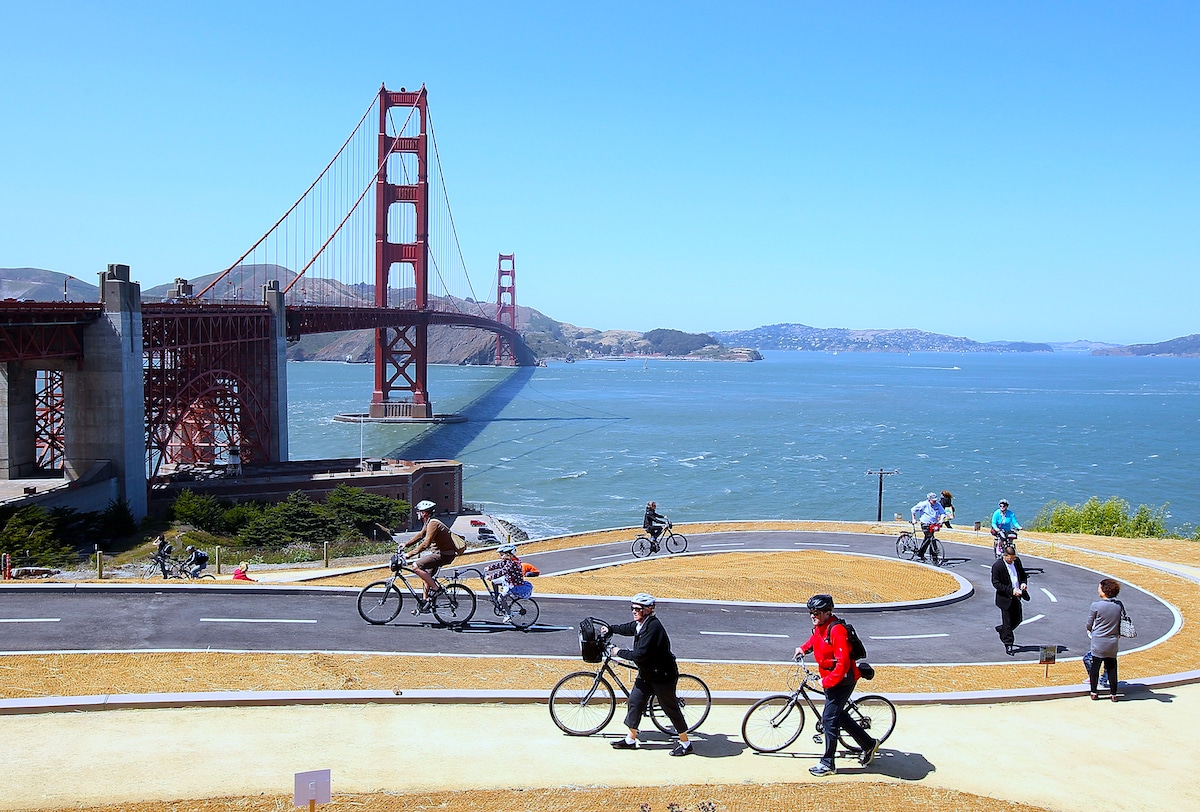 Tourists ride bicycles on a newly constructed bike path near the Golden Gate Bridge in San Francisco, California