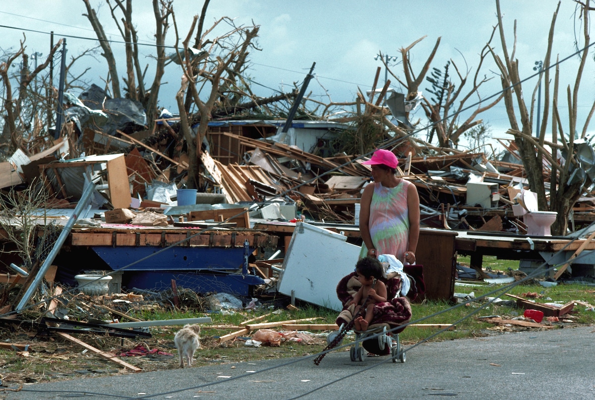 A pregnant woman looks for food and water among the debris left after Hurricane Andrew in Florida