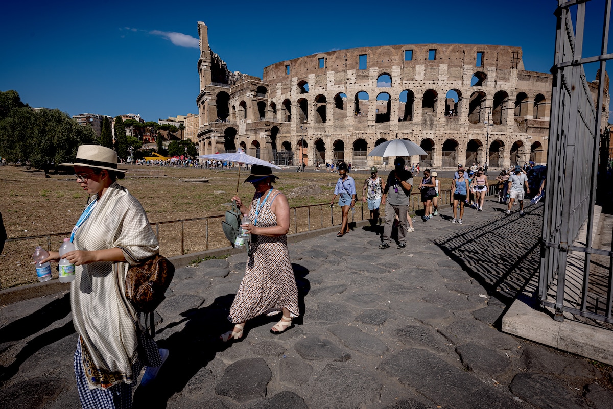 Tourists with umbrellas protect themselves from the sun during named heatwave Nerone in Rome, Italy