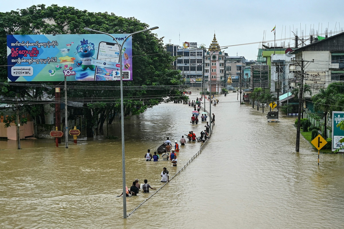 Residents walk through a flooded street after heavy rains in Bago township in Myanmar's Bago region