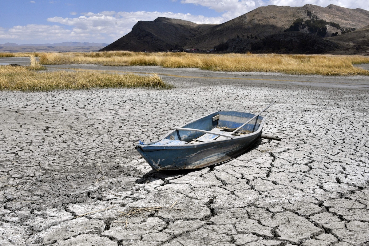 A boat is grounded on cracked earth in the Bahía de Cohana area of Lake Titicaca, shared by Bolivia and Peru