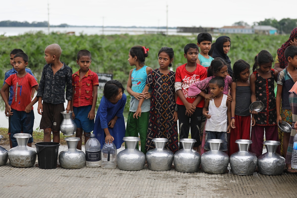 Children wait in line to collect safe drinking water in a flooded area in Companiganj, Sylhet, Bangladesh