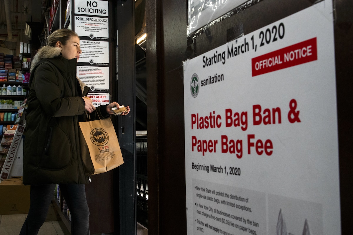 A customer exits a supermarket with paper bags after shopping in New York City