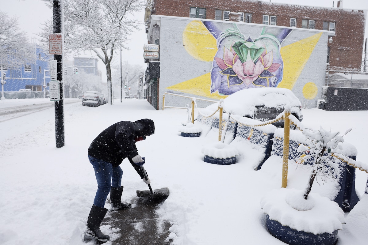 A man clears the snow outside of his workplace in Lawrence, Massachusetts