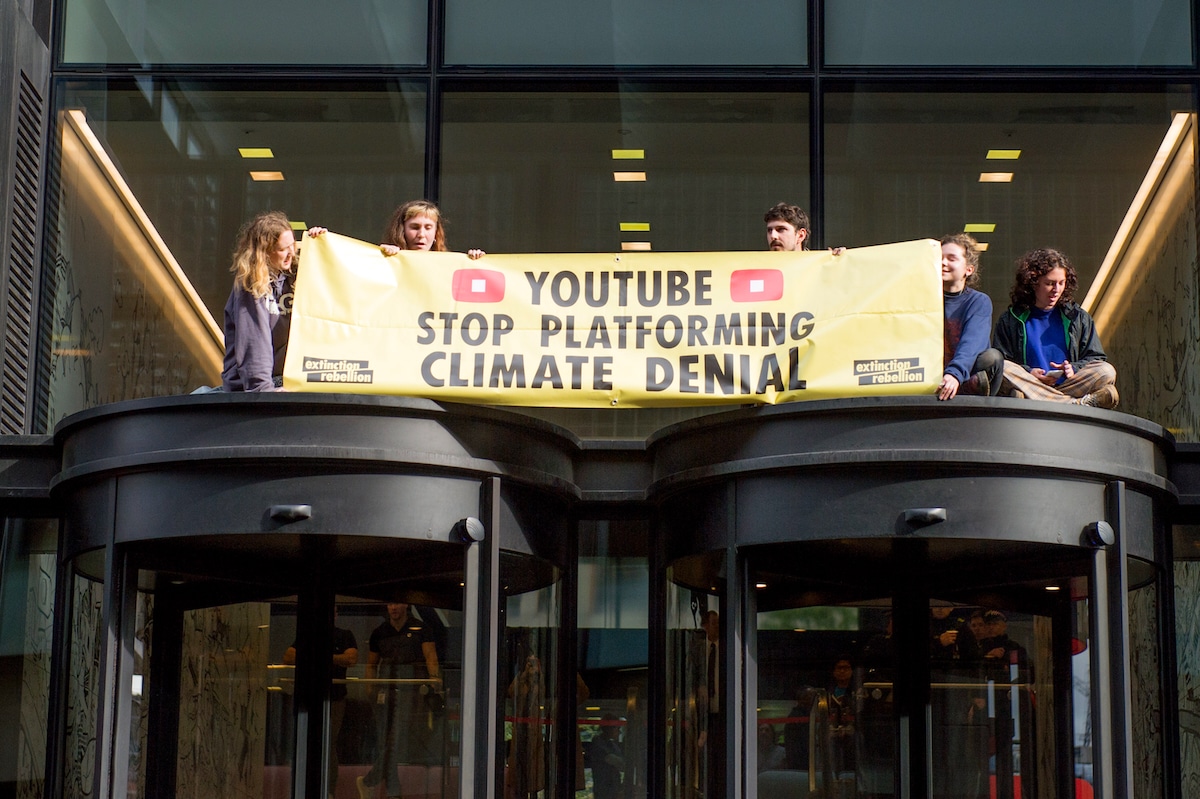 An Extinction Rebellion environmental activist protest on the roof of the entrance to YouTube in London, England, demanding they stop climate deniers profiting on their platform