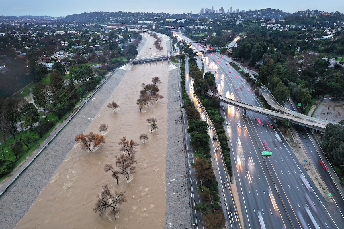 An aerial view of the Los Angeles River swollen by storm runoff as a powerful long-duration atmospheric river storm, the second in less than a week, continues to impact Southern California