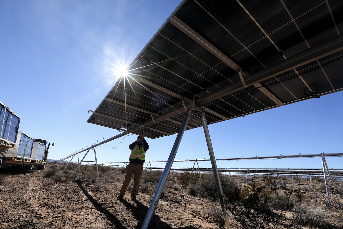 A worker secures mounting straps for solar panel installation at the Gemini solar project in Las Vegas, Nevada
