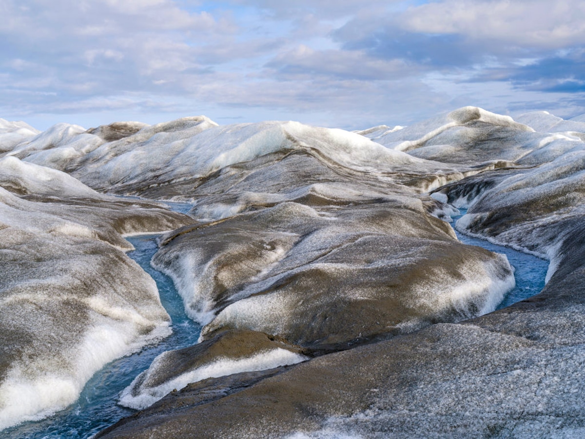 Water draining and brown sediment created by rapid melting of the Greenland ice sheet near Kangerlussuaq, Greenland