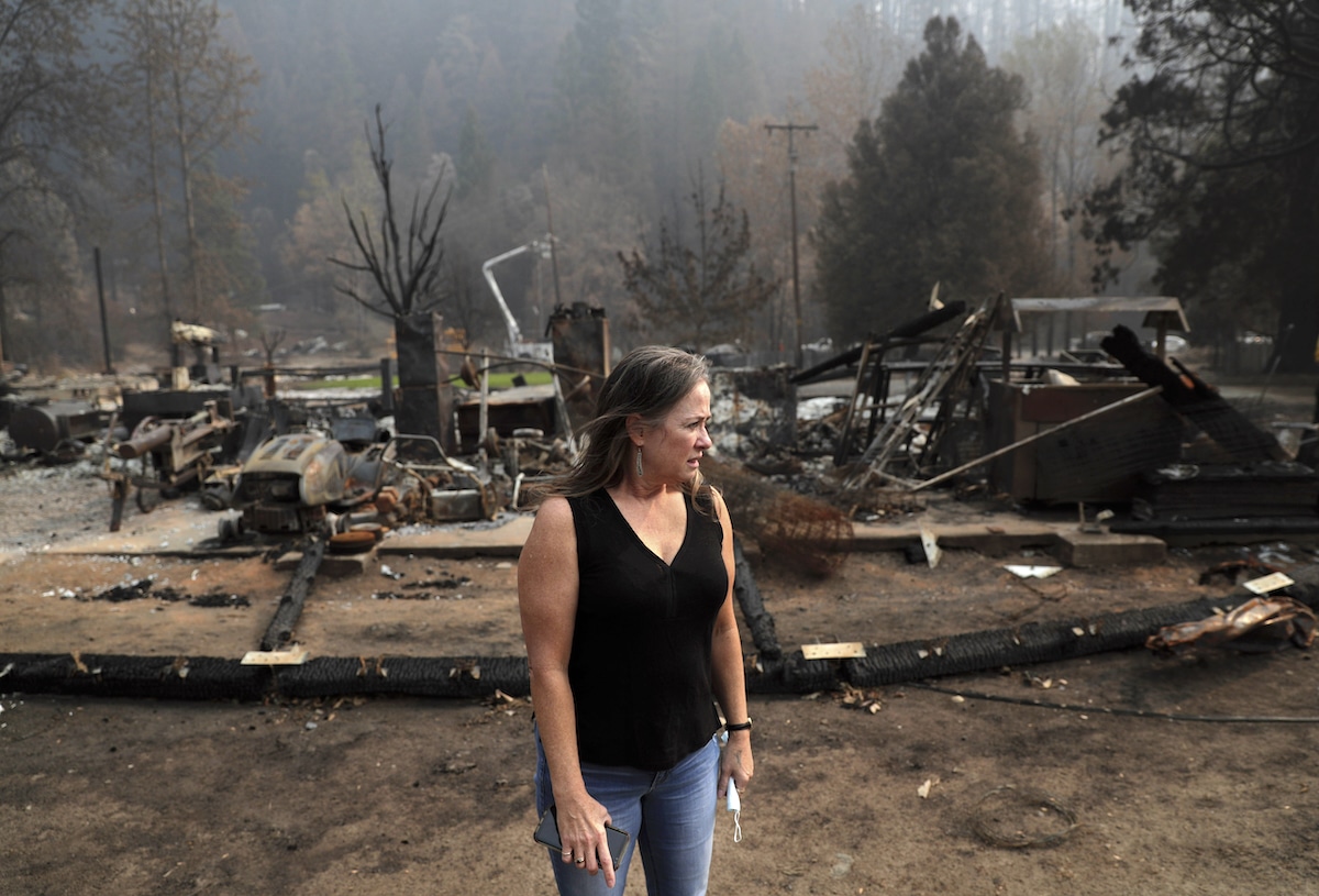 A member of the indigenous Karuk Tribe in Happy Camp, California surveys the damage to her home after the Slater Fire burned thousands of acres in 2020
