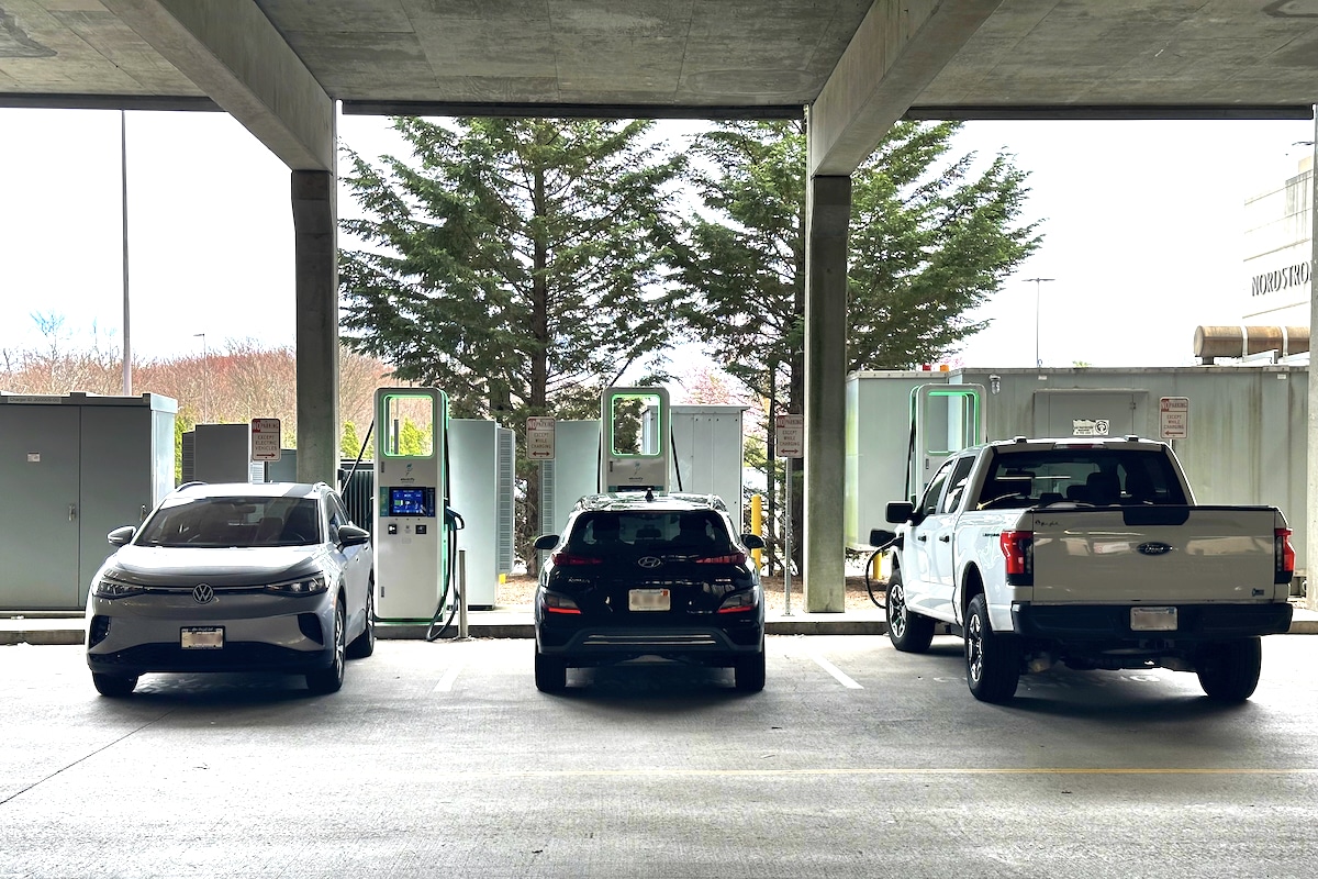 Three electric vehicles charging at Electricity America EV charging station in a parking garage at a shopping mall in Boston, Massachusetts