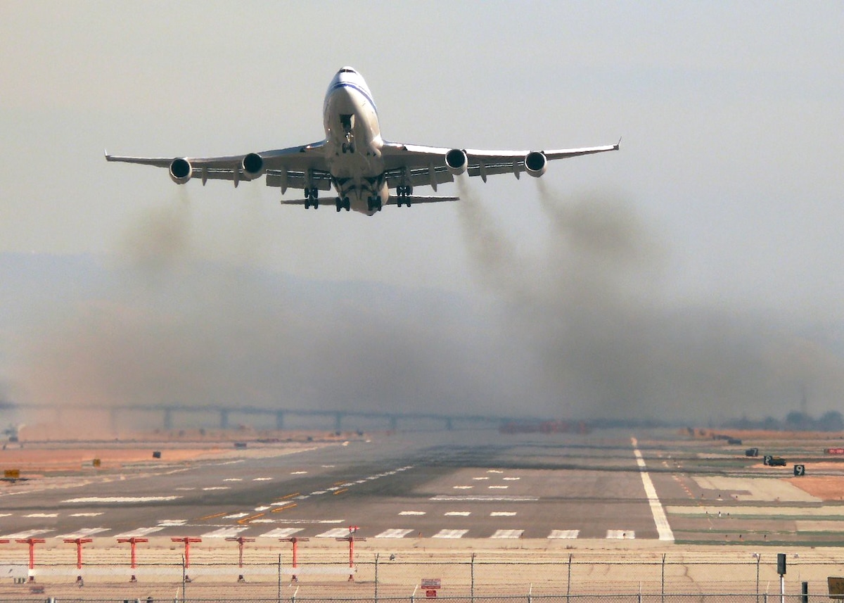 An Air China B-2471 takes off at San Francisco International Airport, leaving a trail of smoke